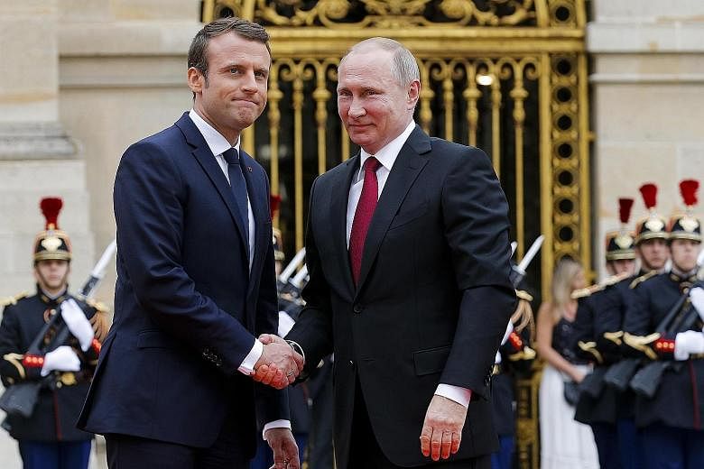 French President Emmanuel Macron (left) with Russian President Vladimir Putin at Versailles, near Paris yesterday. Mr Macron will use an exhibition on Peter the Great at the palace to try to get bilateral ties off to a new start.