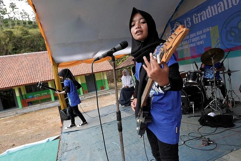 Heavy metal group Voice of Baceprot, led by Firdda Kurnia (right), performing during a school's farewell event in Garut, Indonesia.