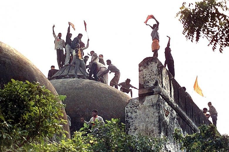 Above: Water Resources Minister Uma Bhartiwas among Mr Narendra Modi's party leaders who were charged yesterday. Right: People clamouring on top of Babri Mosque on Dec 6, 1992, five hours before the structure was demolished by hundreds supporting Hin
