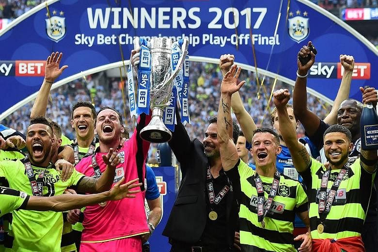 Huddersfield's players and manager David Wagner celebrating the club's historic promotion to the Premier League.