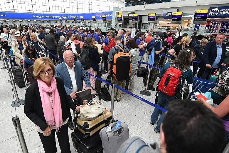 British Airways passengers in Heathrow Airport on Monday. The airline was due to resume a full flight schedule yesterday after a computer outage led to thousands of stranded passengers at the weekend.