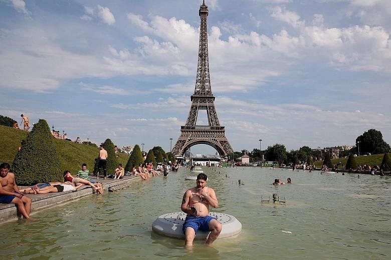 A sunny day at the Fountain of Warsaw and the Eiffel Tower in Paris at the weekend. The costs for cities to limit climate change, including the local heat impact, could be 2.6 times higher than without the urban heat island effect, says the study.