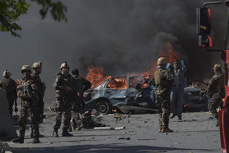 Above: Afghan officials inspecting the damage outside the German Embassy after the blast in Kabul yesterday. From far left: Buildings and vehicles were destroyed, and most of the casualties were Afghans.