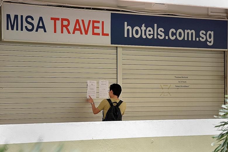 Misa Travel's office at Hong Lim Complex was shut yesterday. A notice put up on the shutters (far right) says the company is no longer in business.