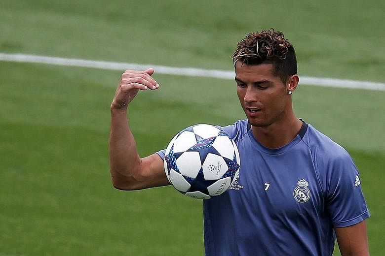 Real Madrid's Cristiano Ronaldo looking at the ball during a training session on Wednesday ahead of the Champions League final against Juventus tomorrow. The Portuguese has scored 14 goals in his last nine games and will be seeking to increase his ta