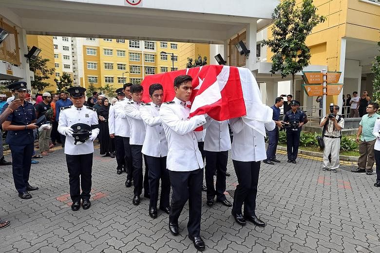 Police officers carrying the casket of Staff Sergeant Nadzrie Matin to a hearse in Choa Chu Kang Avenue 5 yesterday.