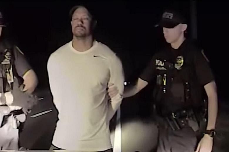 This still image from a police vehicle dash-cam video released by the Jupiter, Florida, police department shows officers arresting former world No. 1 Tiger Woods on Monday. He wobbled as he tried to walk along a straight line in a field sobriety test