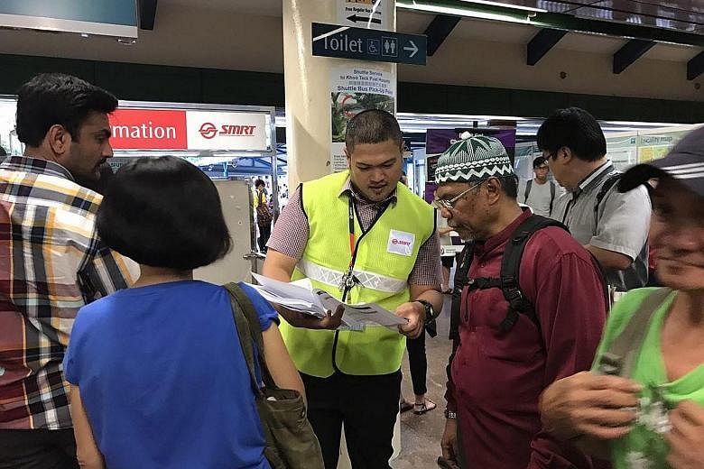 An SMRT employee in Yishun handing out pamphlets on alternative modes of transport to commuters yesterday. The delays yesterday and on Thursday were caused by two unrelated faults uncovered during checks on the line's new signalling system.