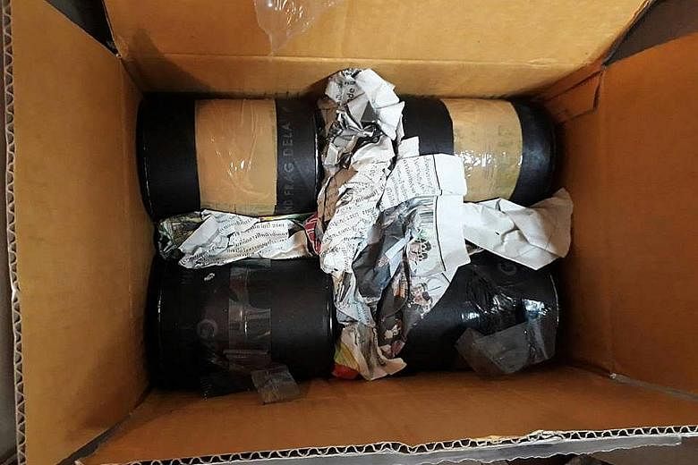 Police dispatched an Explosive Ordnance Disposal team to the shop (left) and found the grenades wrapped in black plastic tape inside the box (above). The grenades were "live" and had a kill zone of 5m and casualty radius of up to 15m.