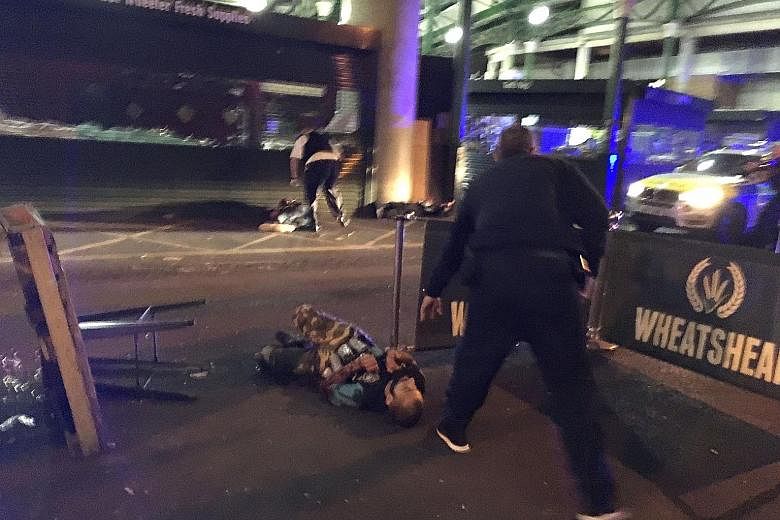 Police standing over two suspects shot at the scene of a terror attack outside Borough Market in central London last Saturday. The attack claimed seven lives and left more than 40 injured. Yesterday, police arrested as many as 12 people after raiding