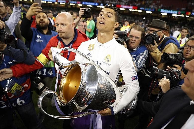 Real Madrid forward Cristiano Ronaldo celebrating with the Champions League trophy. The Spanish side became the first team to retain the Cup in its current format.