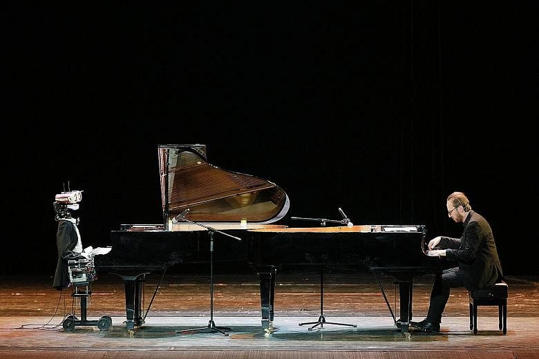 A 53-finger robot pianist called Teotronica and Italian pianist Roberto Prosseda performing on twin grand pianos at a theatre in Tianjin, north China, on Saturday. The rhythmic bot reportedly can distinguish between the speed of key change and play v