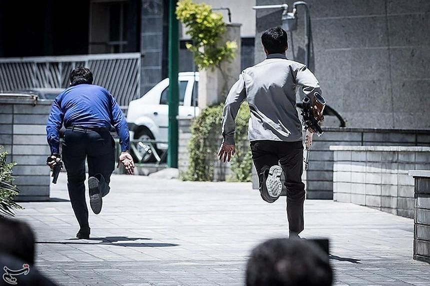 This photo, provided by a third party, shows members of the Iranian government forces swinging into action during the attack at the Parliament building in central Teheran yesterday morning. Policemen being deployed inside Parliament to protect lawmak
