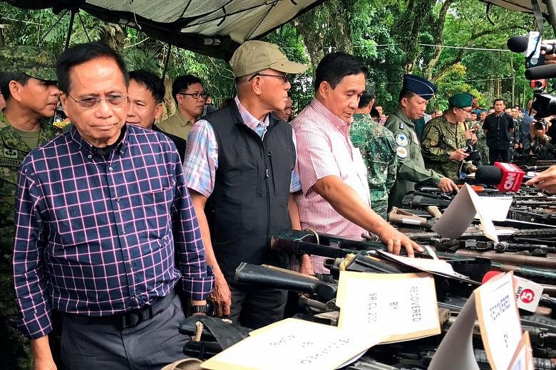 (From left) Presidential adviser on the peace process Jesus Dureza, Philippine Defence Secretary Delfin Lorenzana and National Security Adviser Hermogenes Esperon yesterday inspecting firearms seized in Marawi.