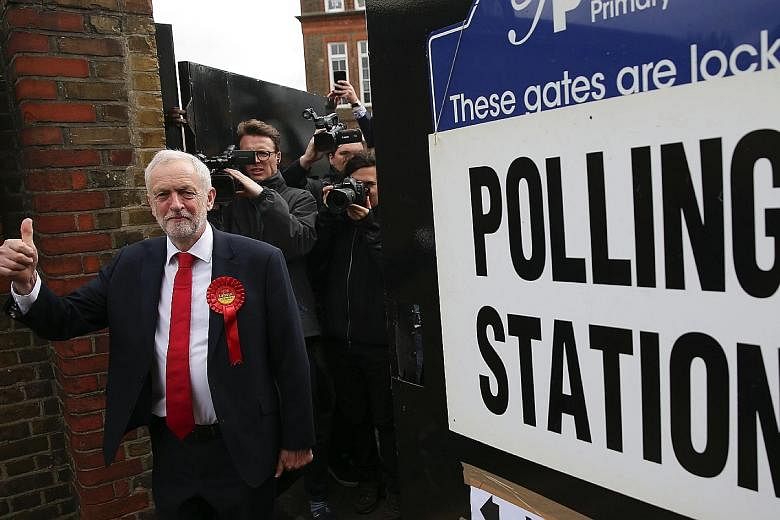 British Prime Minister Theresa May and her husband Philip, and main opposition Labour party leader Jeremy Corbyn, after casting their votes in London yesterday. More than 40,000 polling stations were open, with 46.9 million people registered to vote.