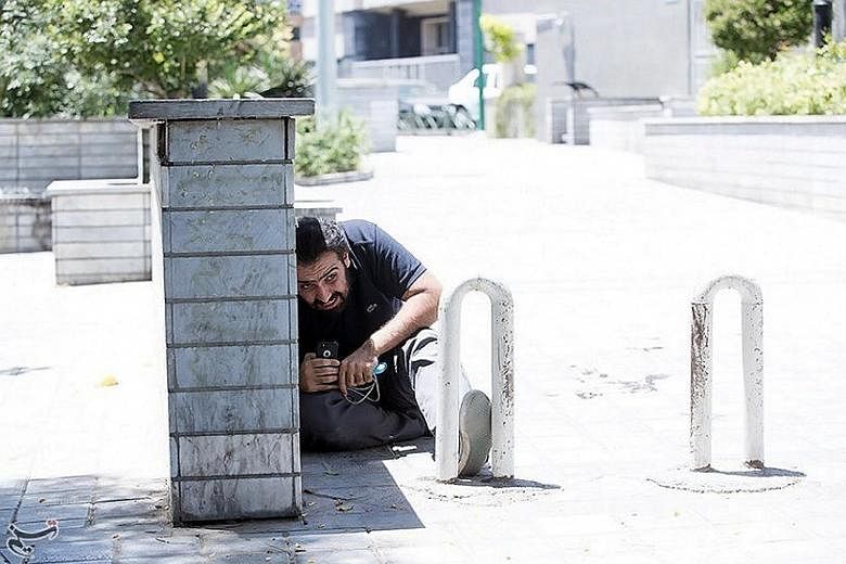 A man taking cover during the attack on the Iranian Parliament complex on Wednesday. The attacks there and at the shrine of revolutionary leader Ayatollah Ruhollah Khomeini were the first in Iran claimed by ISIS.