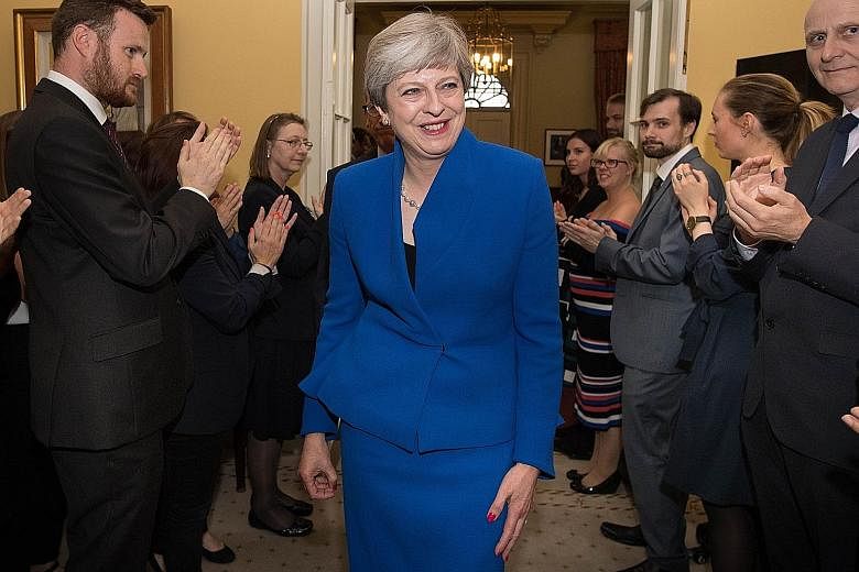 British Prime Minister Theresa May and her husband Philip receiving applause from staff at 10 Downing Street after her audience with Queen Elizabeth II at Buckingham Palace yesterday.
