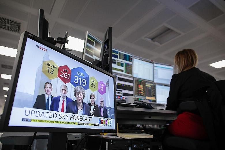 A broker in London monitoring financial data yesterday as results of the UK general election were telecast live.