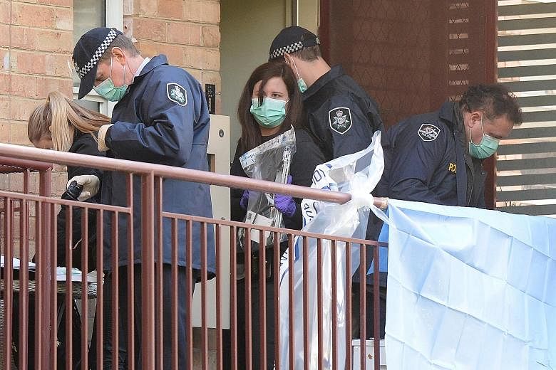 Police officers carrying out a raid at an apartment block in Melbourne yesterday.