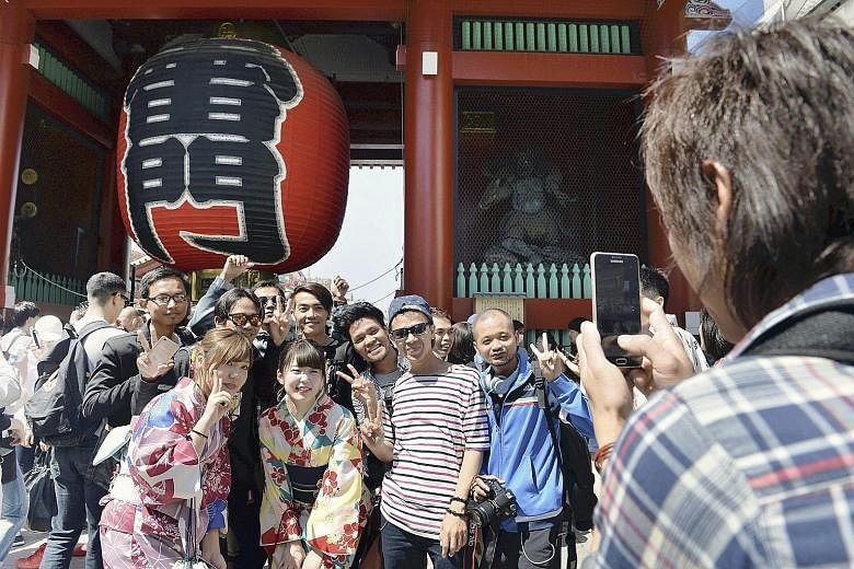 Tourists in front of the Kaminarimon gate in the Asakusa area of Tokyo. Japan has been rewriting tourism records for four straight years, drawing a high of 24 million tourists last year.