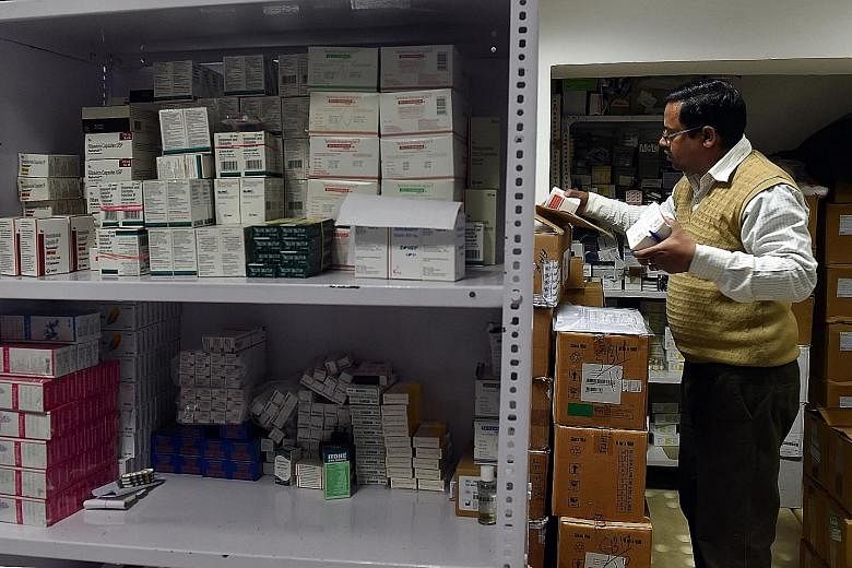 A pharmacy employee gathers drugs for a customer in New Delhi. The government is formulating regulation for online pharmacies, but there have been complaints that these pharmacies are undercutting the business of their bricks-and- mortar rivals throu