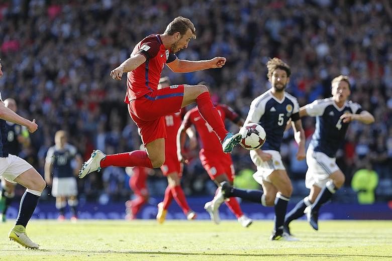 An airborne Harry Kane volleying home the dramatic injury-time equaliser for a 2-2 draw in England's World Cup qualifier against Scotland. His team are on top of Group F with 14 points from six matches, two clear of Slovakia who are second in the gro