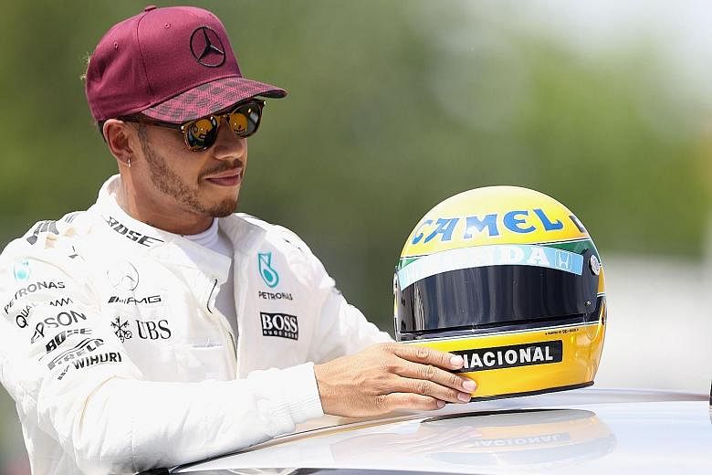 Lewis Hamilton with the replica of a helmet belonging to the late F1 world champion Ayrton Senna, whose record of 65 pole positions he equalled in Montreal for the Canadian Grand Prix.