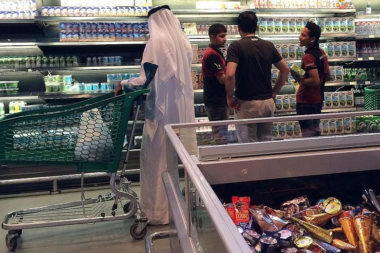 Customers at the al-Meera market in the Qatari capital Doha on Saturday. The blockade has disrupted food and material supplies to import- dependent Qatar. Iran yesterday said it had sent four cargo planes of food to Qatar and plans to provide 100 ton