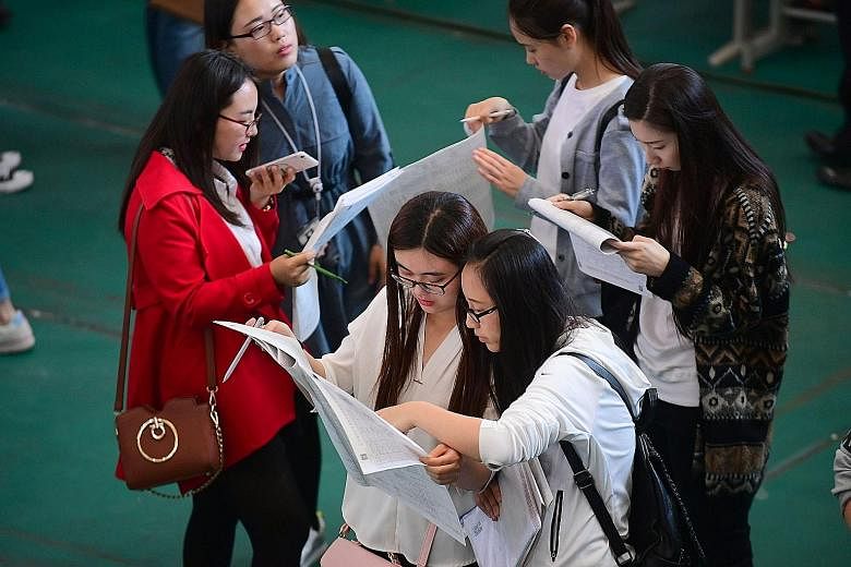 Students looking at job postings at a job fair at Shenyang Aerospace University in Shenyang, China's north-east Liaoning province, last month. More than three-quarters of recent graduates said they experienced discrimination of some form, with employ
