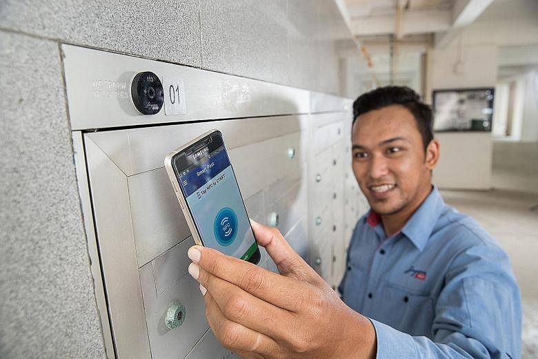 A Singapore Post employee demonstrating the use of the SmartPost app on a smartphone at a near-field communication (NFC) tag. By March 2019, more than 50,000 letterbox nests will be tagged with NFC. SingPost said it plans to tag every letterbox nest 