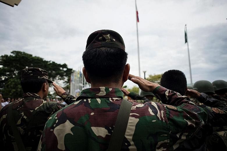 Soldiers at an emotional flag-raising ceremony in Marawi yesterday, to mark the Philippines' independence day and remember those killed in the ongoing crisis there.