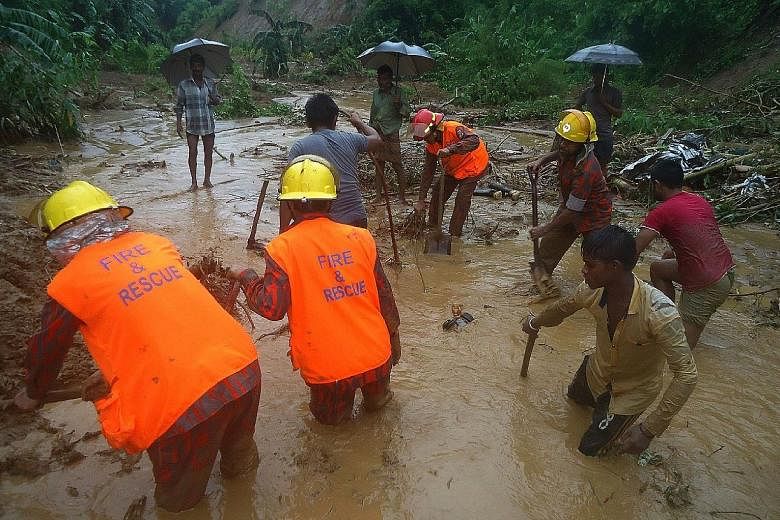 Bangladeshi firefighters and residents searching for bodies after a landslide in Bandarban yesterday. Heavy monsoon rains have killed many people in south-east Bangladesh, most of them buried under landslides, the authorities said.