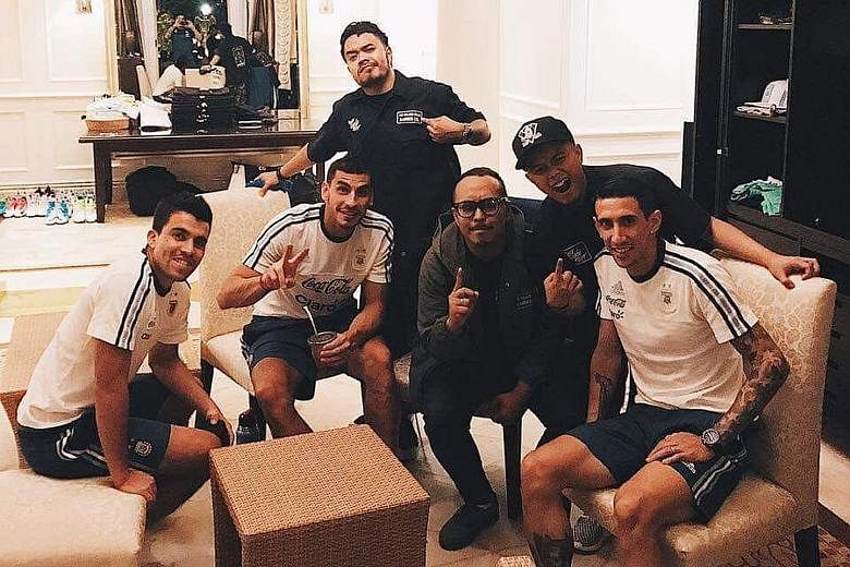 Barbers from The Golden Rule Barber Co. posing with Argentina winger Angel di Maria and his team-mates after giving several Argentina players a haircut at the Fullerton Hotel yesterday.