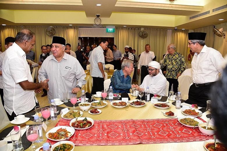 At the breaking of fast session organised by the Religious Rehabilitation Group (RRG) and the Khadijah Mosque in Geylang yesterday were (from left) Minister for Home Affairs and Law K. Shanmugam, RRG co-chair Ali Mohamed, Acting Prime Minister Teo Ch