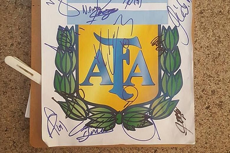 […]Above: A Singaporean fan's clipboard filled with coveted autographs from players of the Argentinian team. Left: Argentinian winger Angel di Maria about to depart in a bus heading from Fullerton Hotel to Changi Airport[/…] last night.