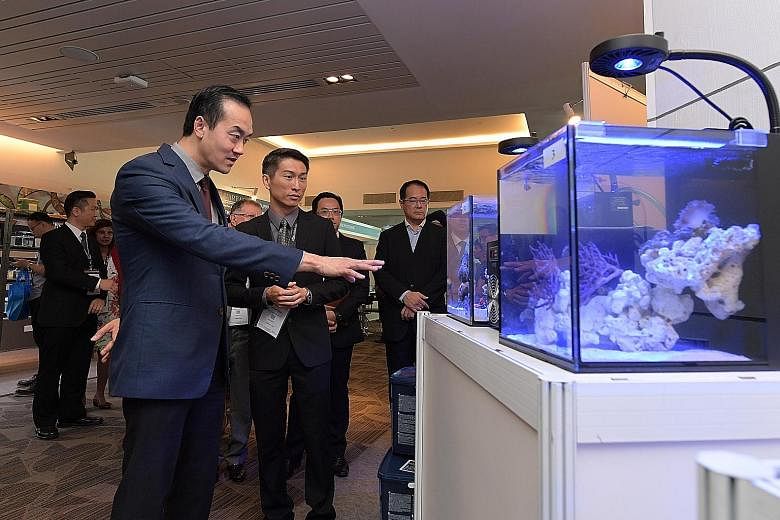 Dr Koh Poh Koon checking out an exhibit at the inaugural AquaRealm 2017, accompanied by Mr William Chew, chairman of the Singapore Aquarium Fish Exporters' Association.
