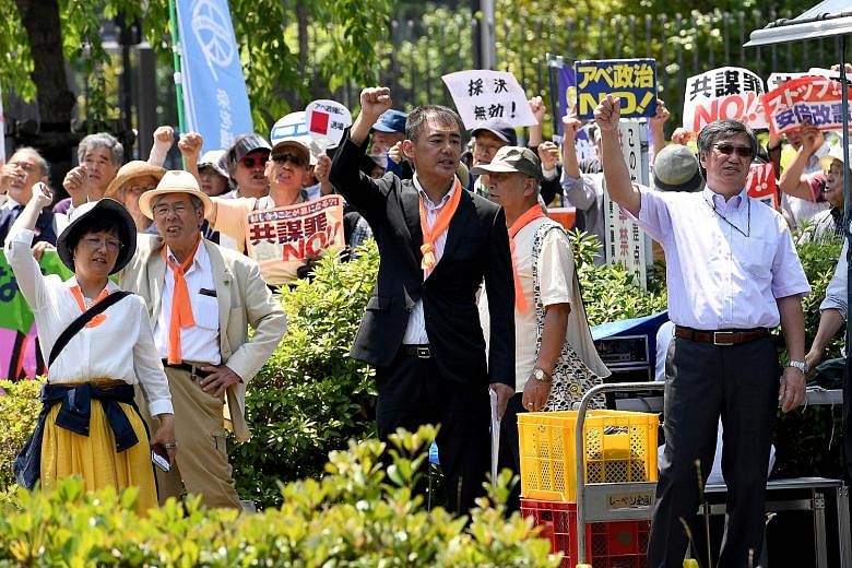 Demonstrators protesting against the controversial "anti-conspiracy Bill" near the Parliament building in Tokyo yesterday, after the Upper House passed it. The law punishes 277 crimes and takes effect next month.