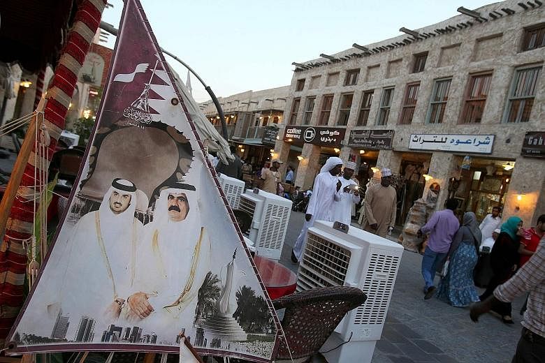 A banner bearing portraits of Qatar's former emir, Sheikh Hamad Khalifa al-Thani (right), and his son the current leader, Sheikh Tamim Bin Hamad al-Thani, in the capital Doha. The current showdown between Qatar and its Gulf neighbours is, at its hear