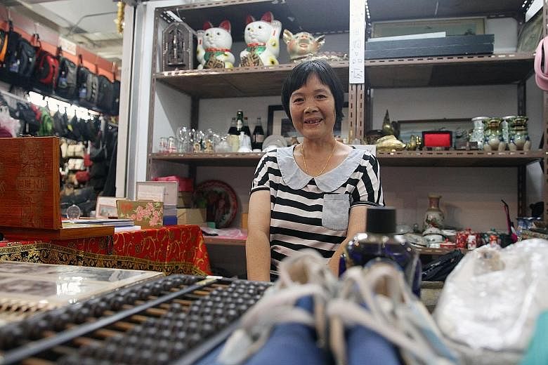 Madam Tan Guo Mei at her new stall at Chinatown Market. She is one of the beneficiaries of the assistance provided to Sungei Road vendors. Besides selling second-hand collectibles, she has started selling new shoes at her stall, which opened for busi