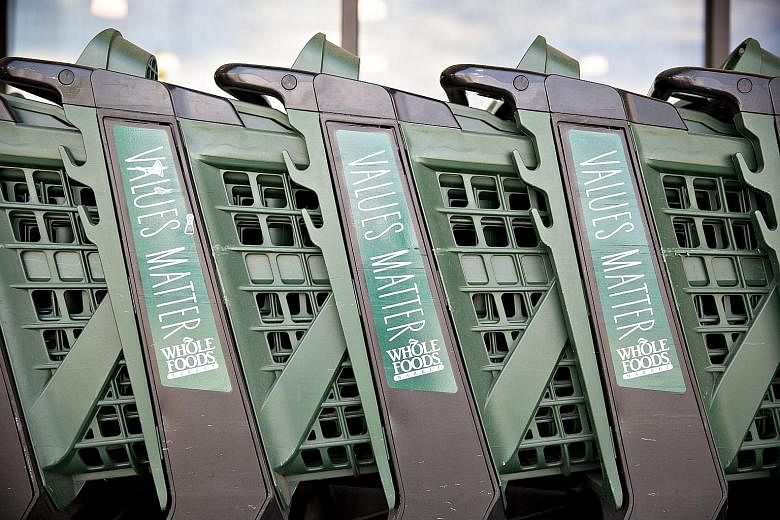 Whole Foods shopping carts outside one of the grocery chain's stores in Illinois, US. The retailer was acquired by Amazon in a $19 billion deal last Friday, signalling Amazon's charge into the supermarket business with Whole Foods' hundreds of physic