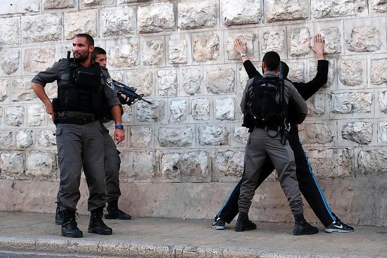 Israeli border guards searching a Palestinian man outside Damascus Gate in Jerusalem's Old City on Friday following an attack. Three Palestinians attacked police officers in the area before being shot dead by security forces. Two of them had opened f