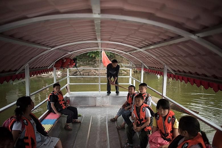 Mr Li Congshu ferrying his pupils after school in Dazu district in south-west China's Chongqing municipality. He has been transporting pupils to and from school for more than 20 years. The crossing of the Xiangshuitan reservoir by boat takes about ha