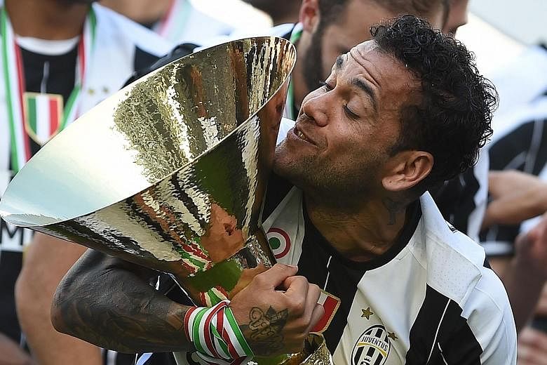 Juventus' Dani Alves holding the Serie A trophy after his club won a sixth straight league title last season. The Brazilian could be challenging for the English Premier League next with Manchester City.