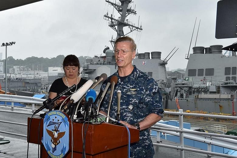 US Seventh Fleet commander Joseph Aucoin in front of the USS Fitzgerald at the US Navy base in Yokosuka, Japan, yesterday. The navy said it had found "a number" of bodies inside the warship, but did not specify if all seven missing crew members had b
