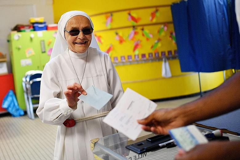 A Catholic nun voting at a polling station in Nantes, western France, yesterday. About half of REM's candidates are newcomers to politics, drawn from diverse fields of academia, business or local activism.
