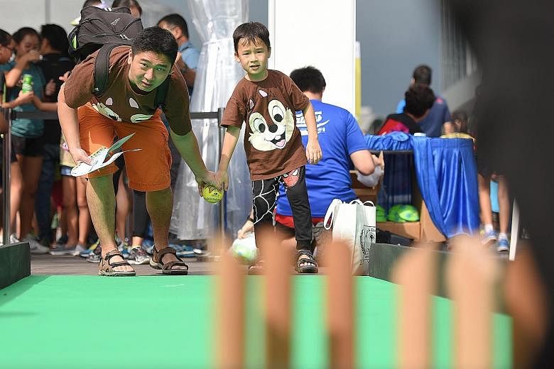 Mr Daniel Chua, 38, a logistics assistant, playing mini bowling with his son Ocean, six, at the Father's Day carnival yesterday.