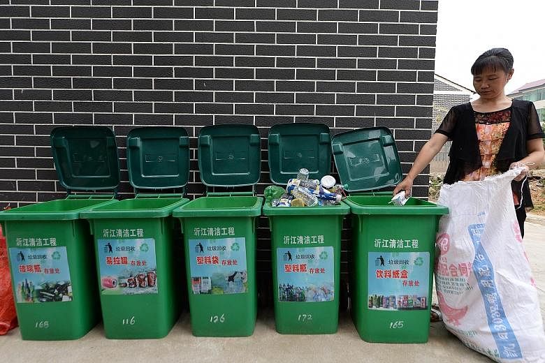 A worker sorting out garbage in a village in China's Jiangxi province. Efforts to encourage recycling and waste-sorting have not been able to keep up with the rising consumption by the country's expanding middle class over the past decade. China is n