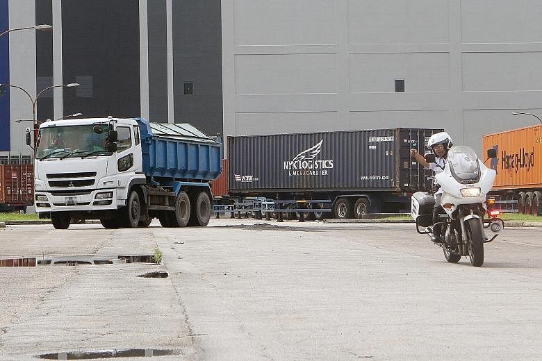 A traffic policeman directing a driver suspected of carrying an overweight load to a spot for inspection yesterday. The blitz by police, LTA and NEA targeted errant drivers after a series of fatal accidents involving heavy vehicles.
