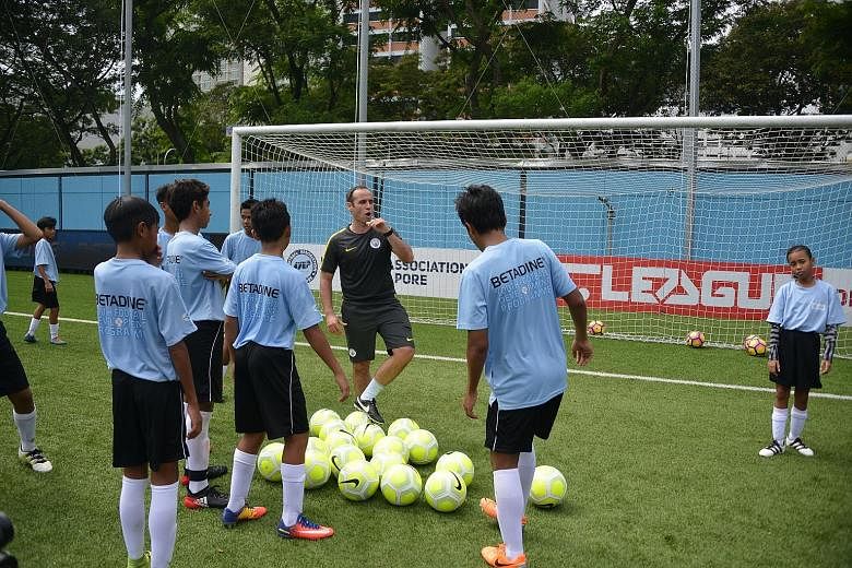 Manchester City youth coach Alan Dixon working with under-15 players at the Betadine Youth Football Development Programme held at Jalan Besar Stadium. He and fellow City youth coach Chris McCarthy will be conducting the clinic throughout the week for