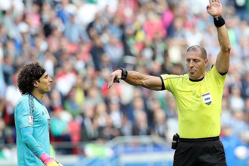 Referee Nestor Pitana relays instructions from the video assistant referee (VAR) to disallow a goal by Portugal due to offside in the Confederations Cup Group A match against Mexico in Kazan, Russia on Sunday.